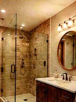 Remodeled bathroom with glass shower and wood vanity